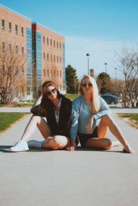 Girls sitting on college campus wondering which questions to ask sorority members